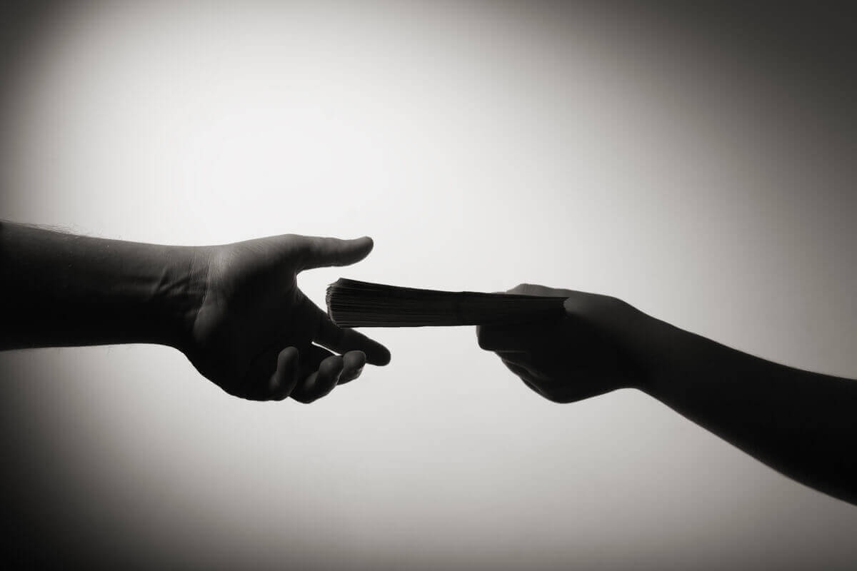 Silhuetten til en person som gir penger til en annen